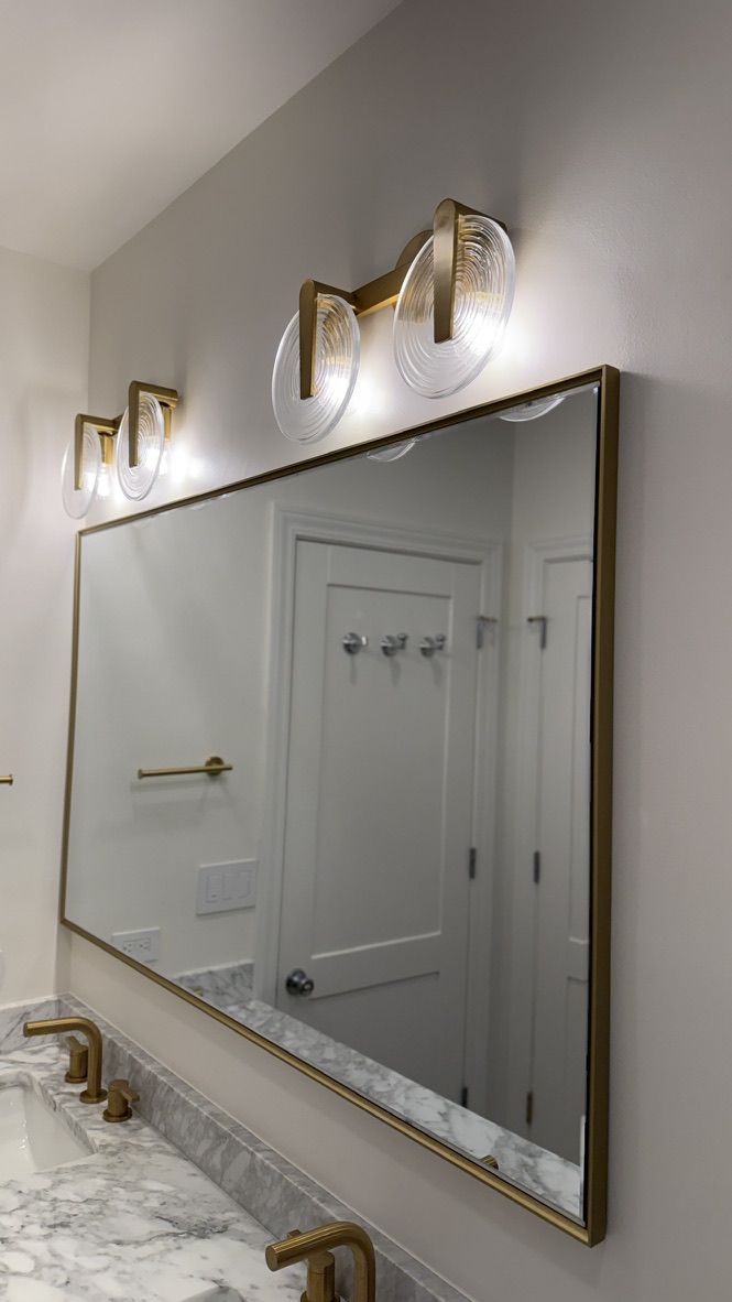Vanity mirror with round brushed brass sconce lighting