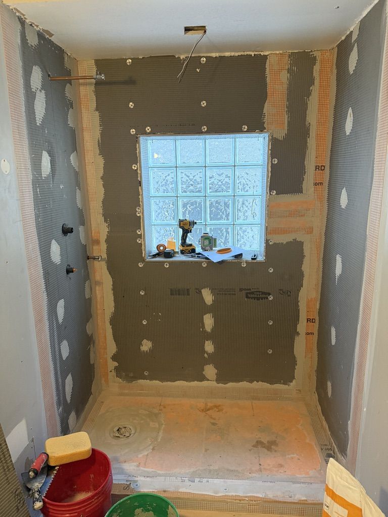 Waterproofing membrane applied to shower walls before tiling
