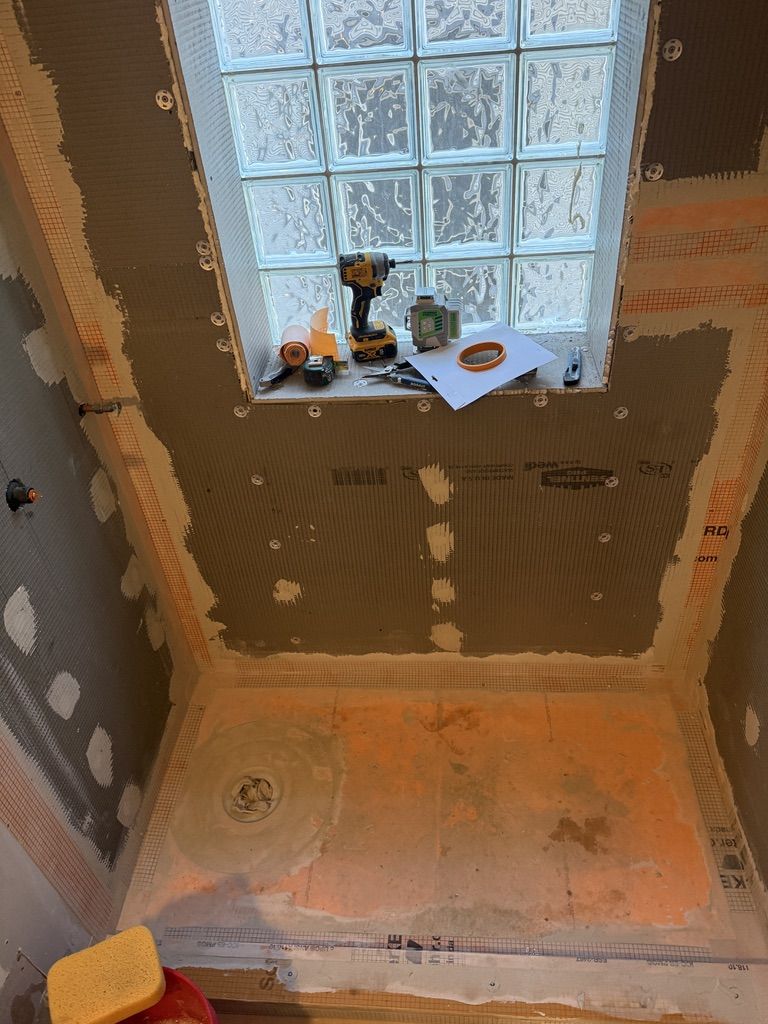 Waterproofed shower floor with drain set before tile