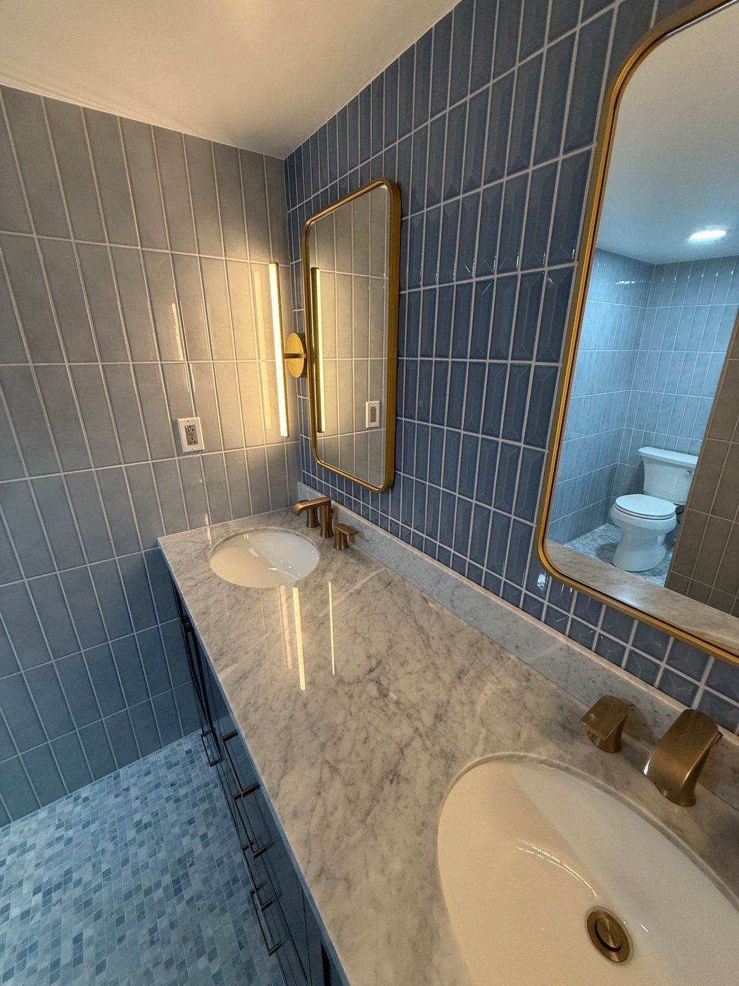 Countertop and sink detail with blue tile and mirrors