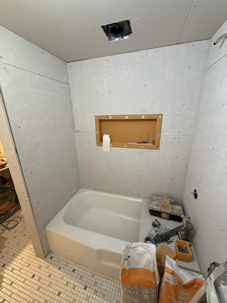New backerboard installed with tub set in place and shower niche framed