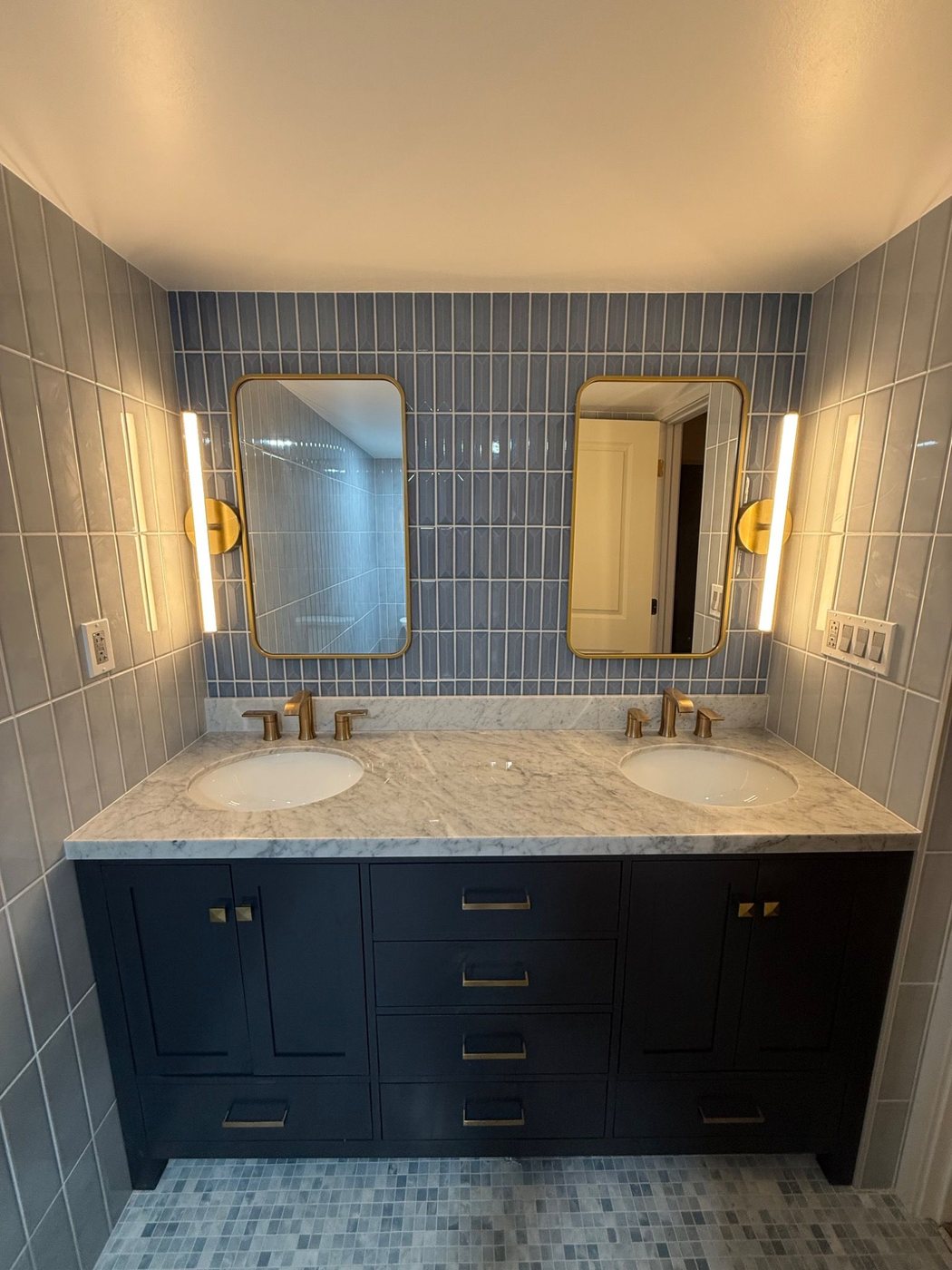 Blue tile double vanity with gold mirrors and lights