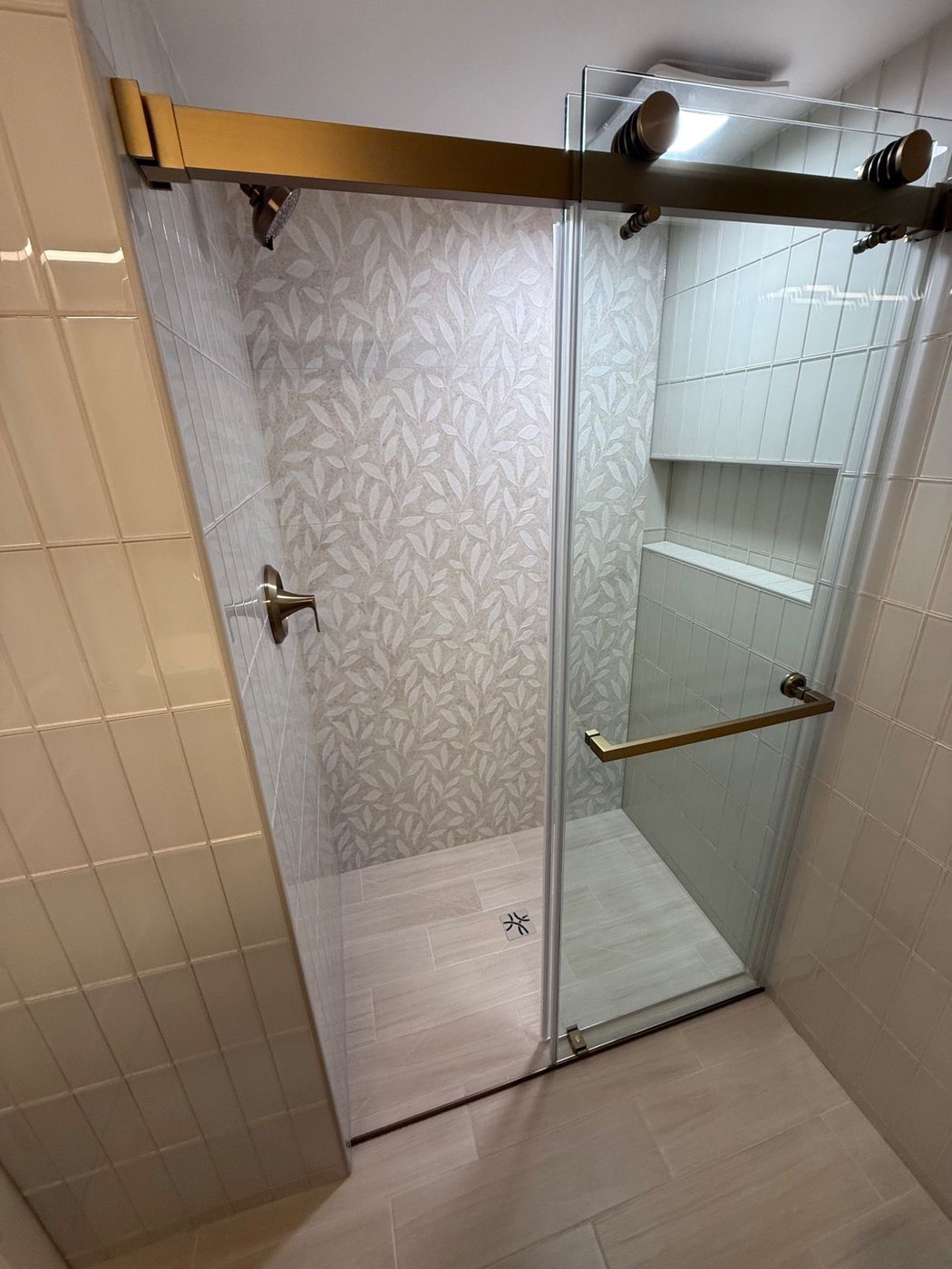 Closer view into the shower with wall tile and drain