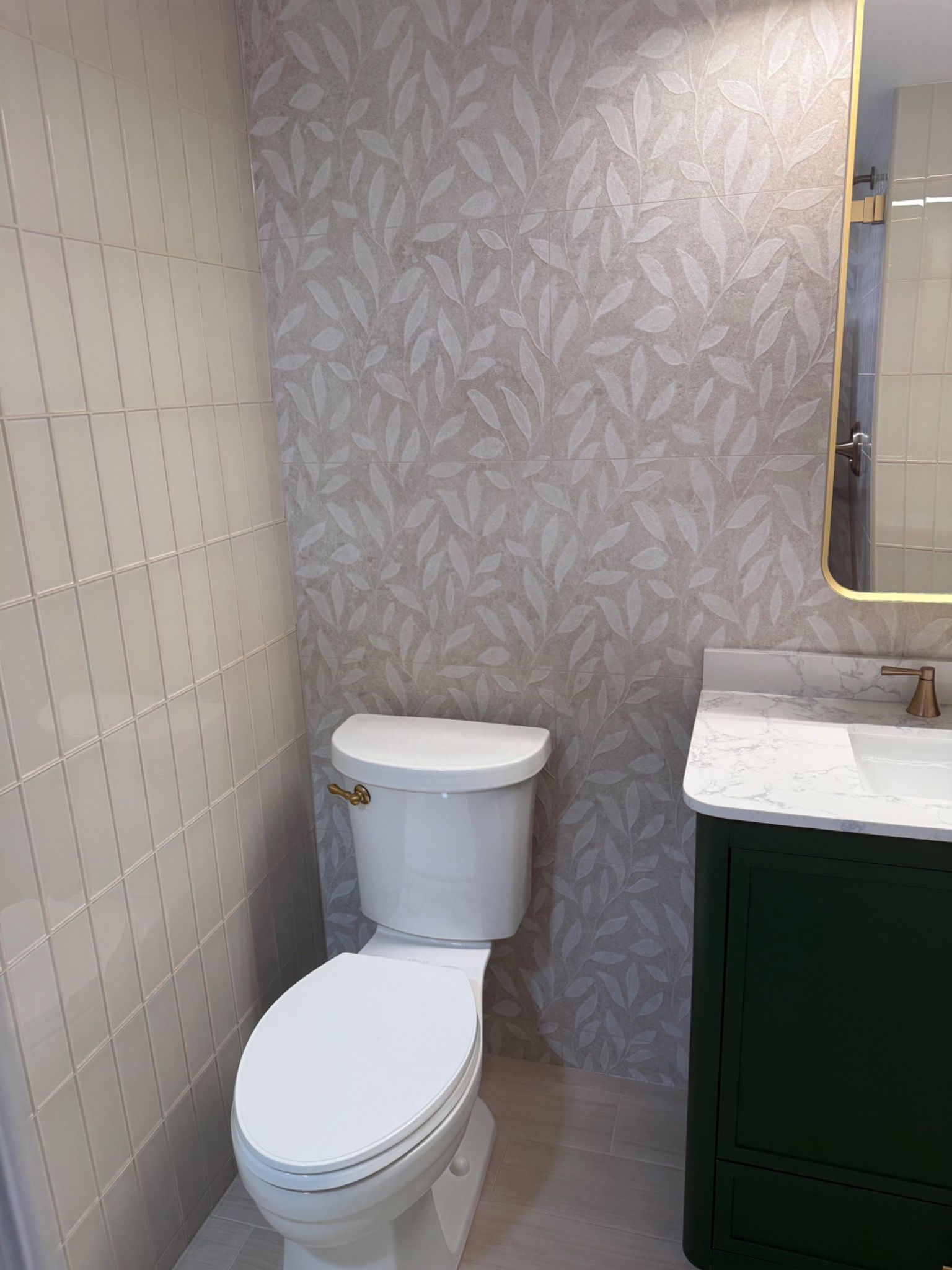 Side view of glass shower enclosure with patterned wall tile