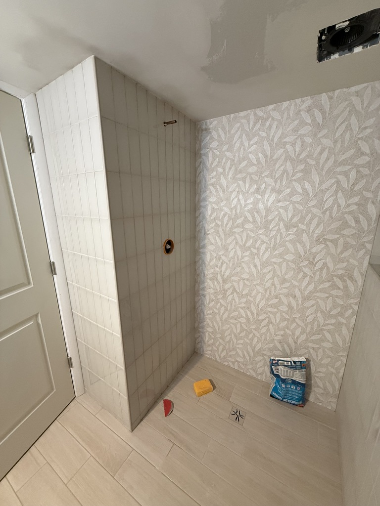 Tile work nearly complete with patterned feature wall before glass door install