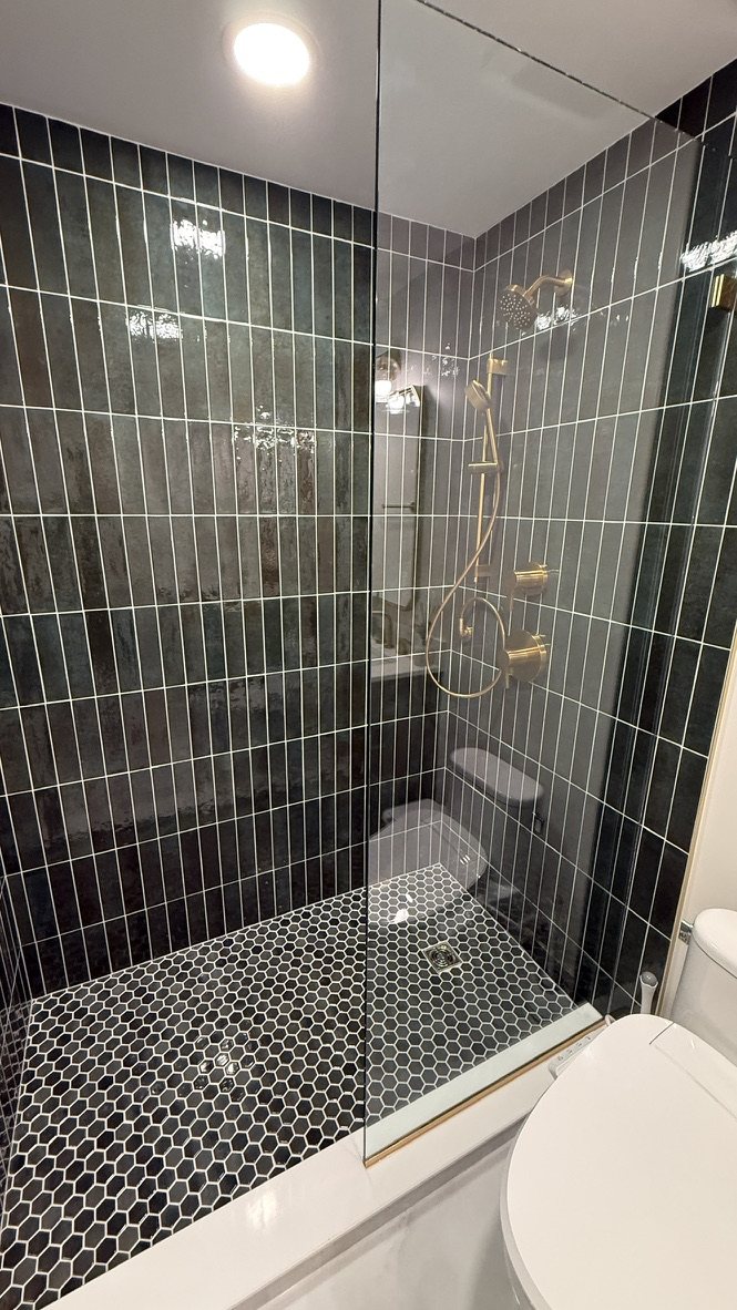 Wide view of the finished walk-in shower with glass door and toilet