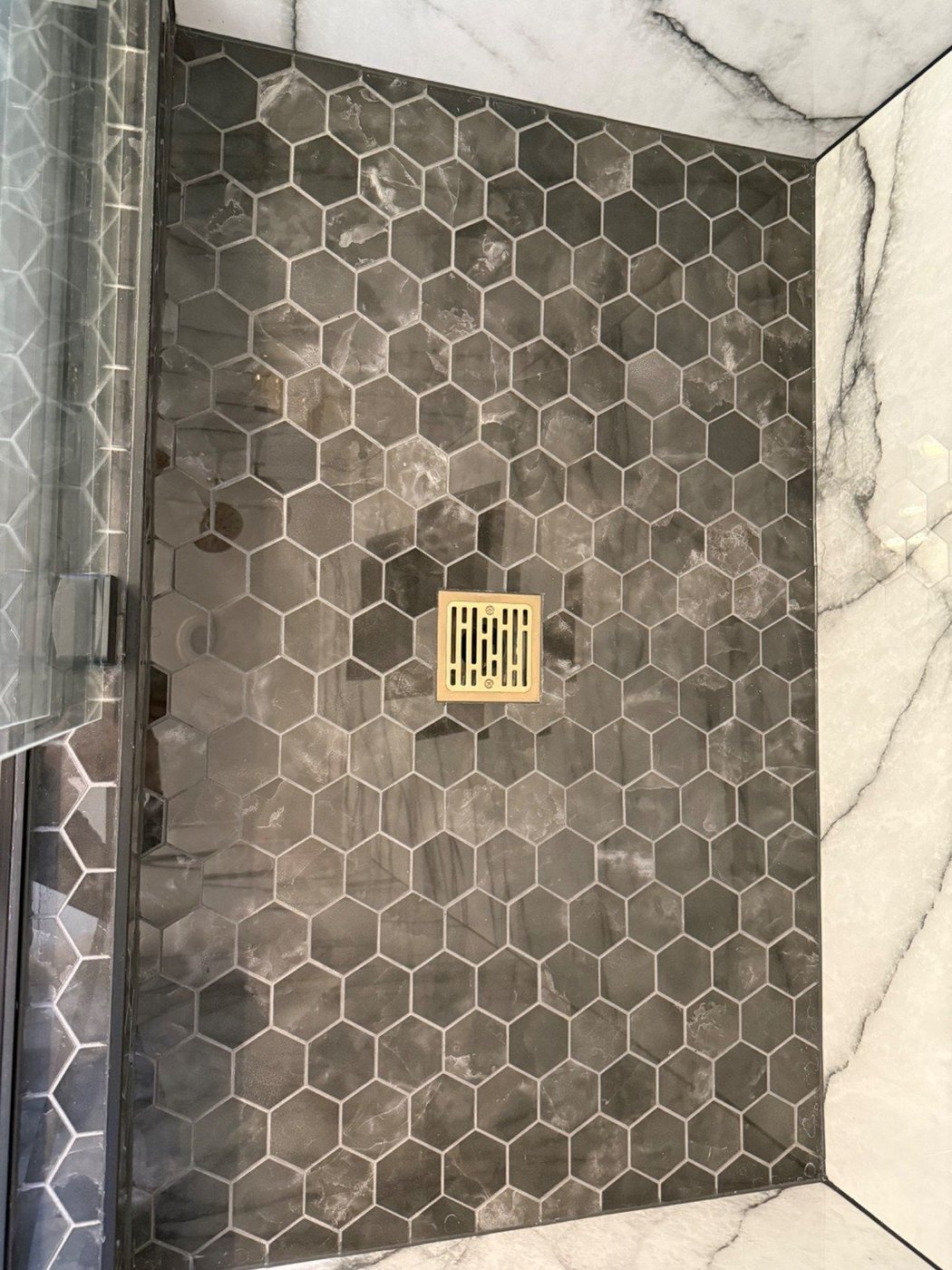 Dark hex shower floor tile with drain