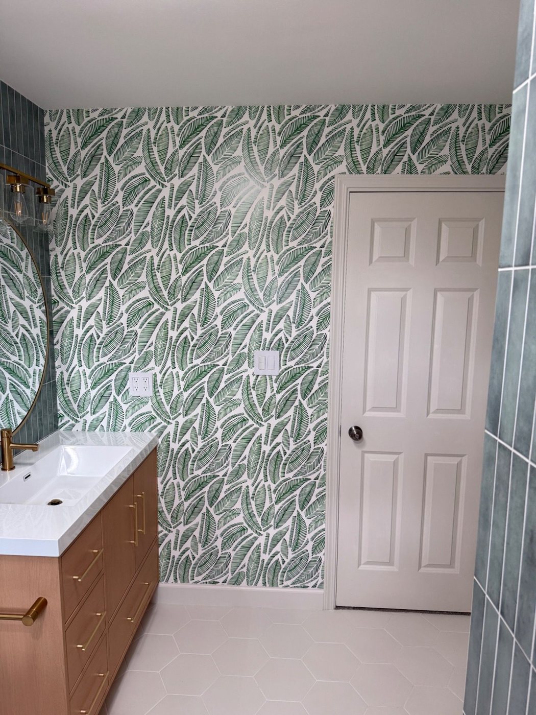 Wallpaper wall and door view in finished bathroom remodel