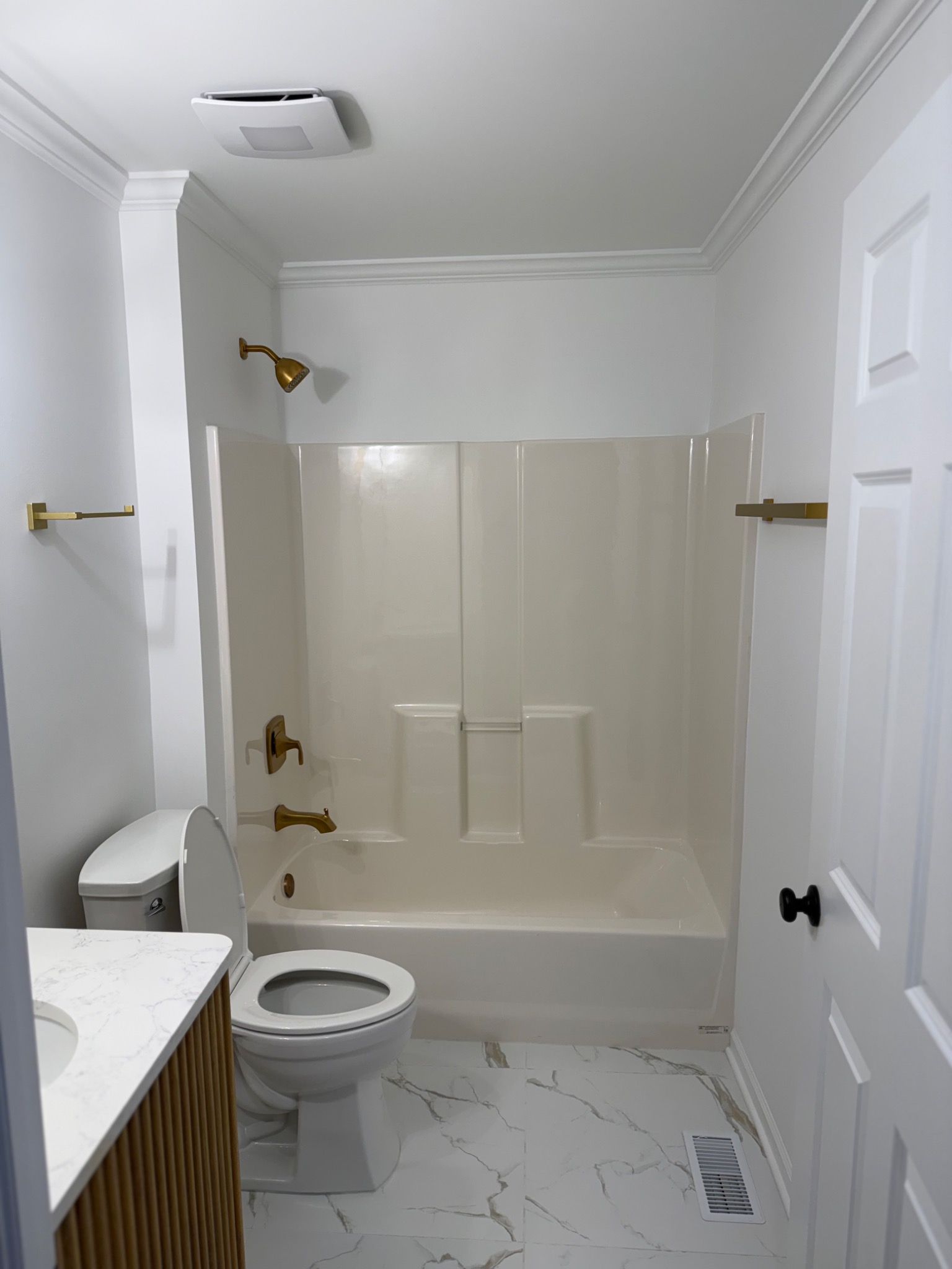 Finished bathroom refresh with fluted vanity, arch mirror, and tub surround