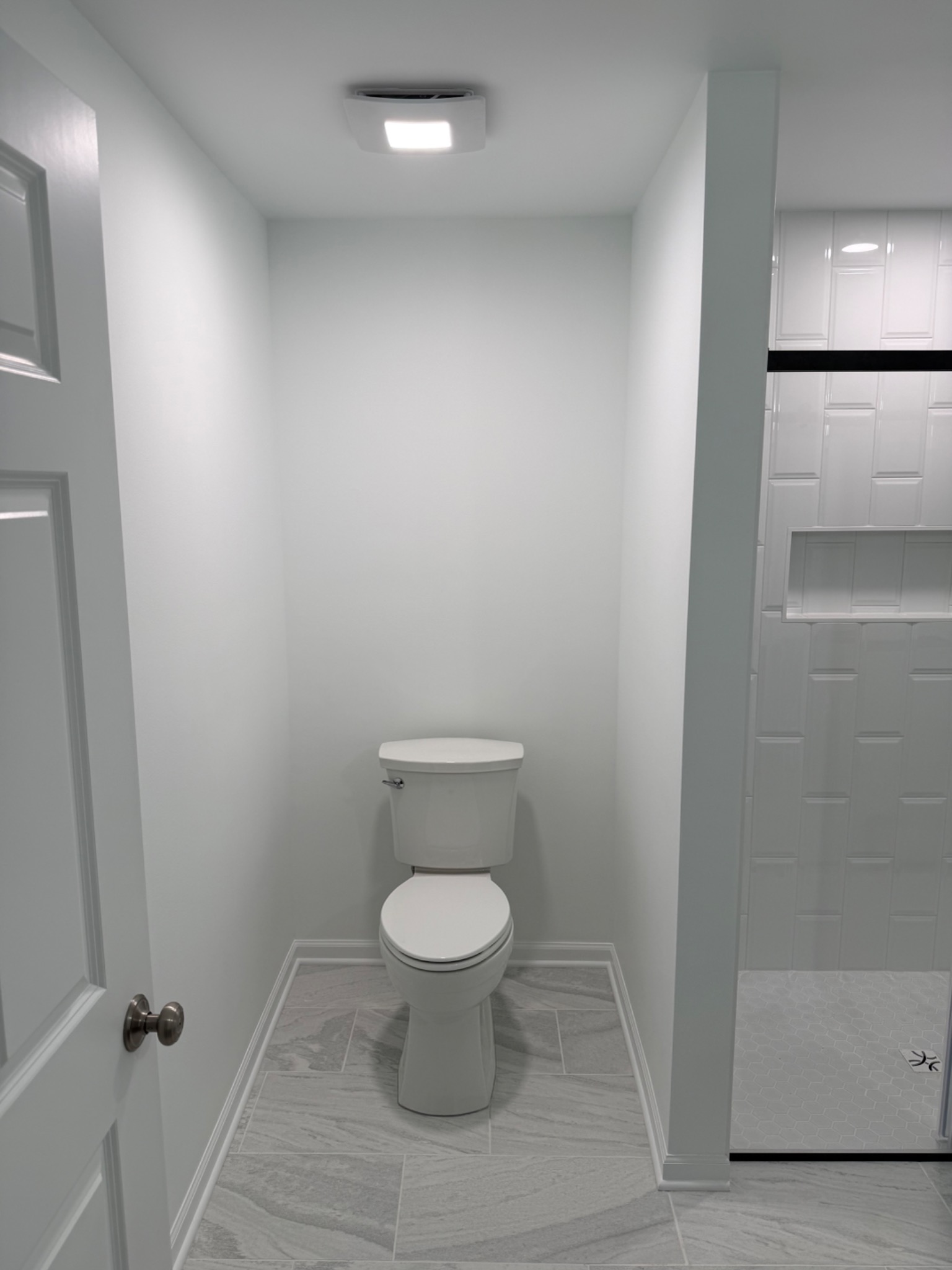 Finished bathroom overview with toilet area and tile floor