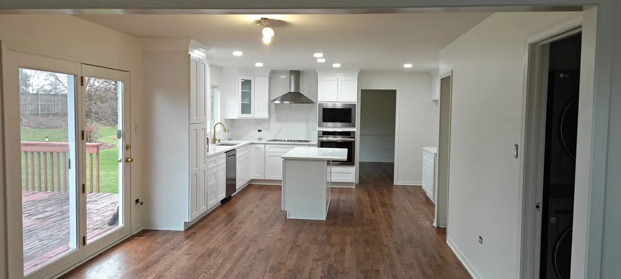 Finished bright kitchen renovation with white cabinetry and island