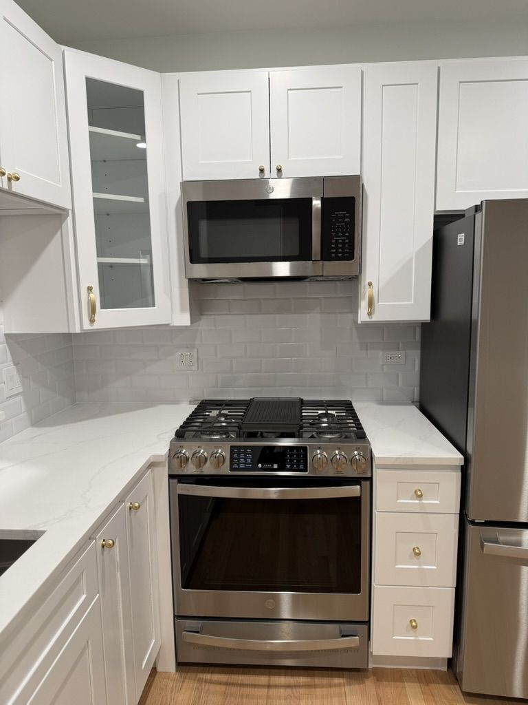 Range and microwave detail next to the stainless refrigerator