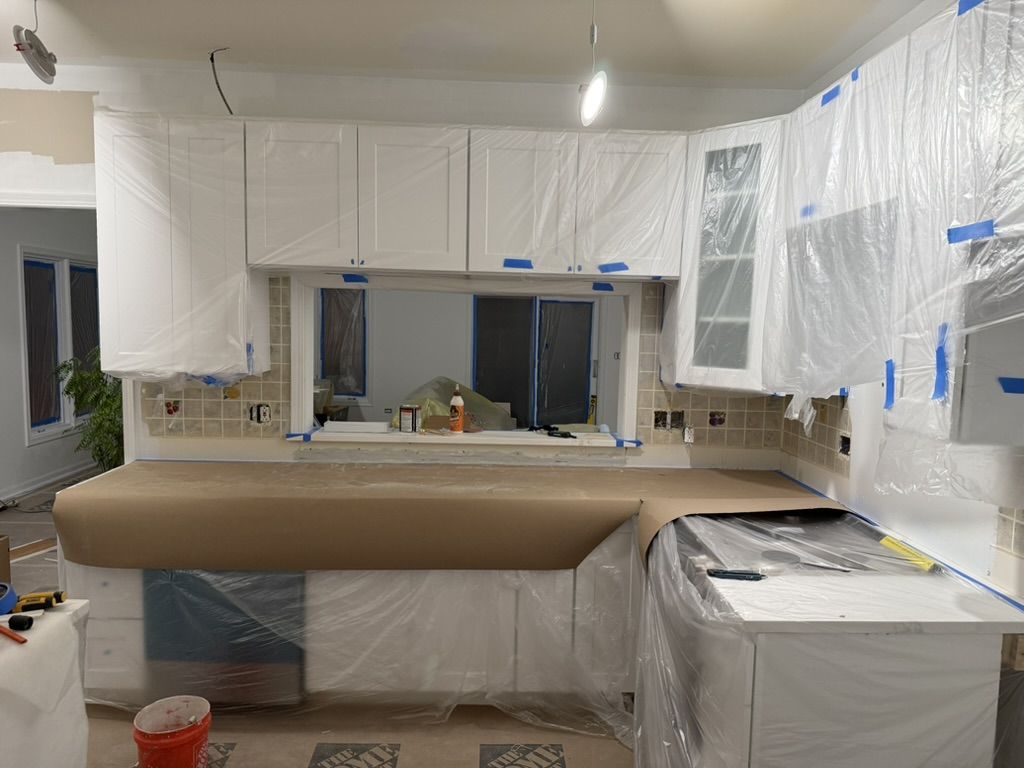 Cabinets wrapped in plastic to protect them during painting